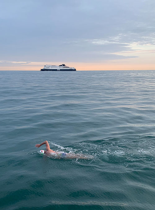 Photo of swimmer in the English channel, ship in the background going opposite direction.
