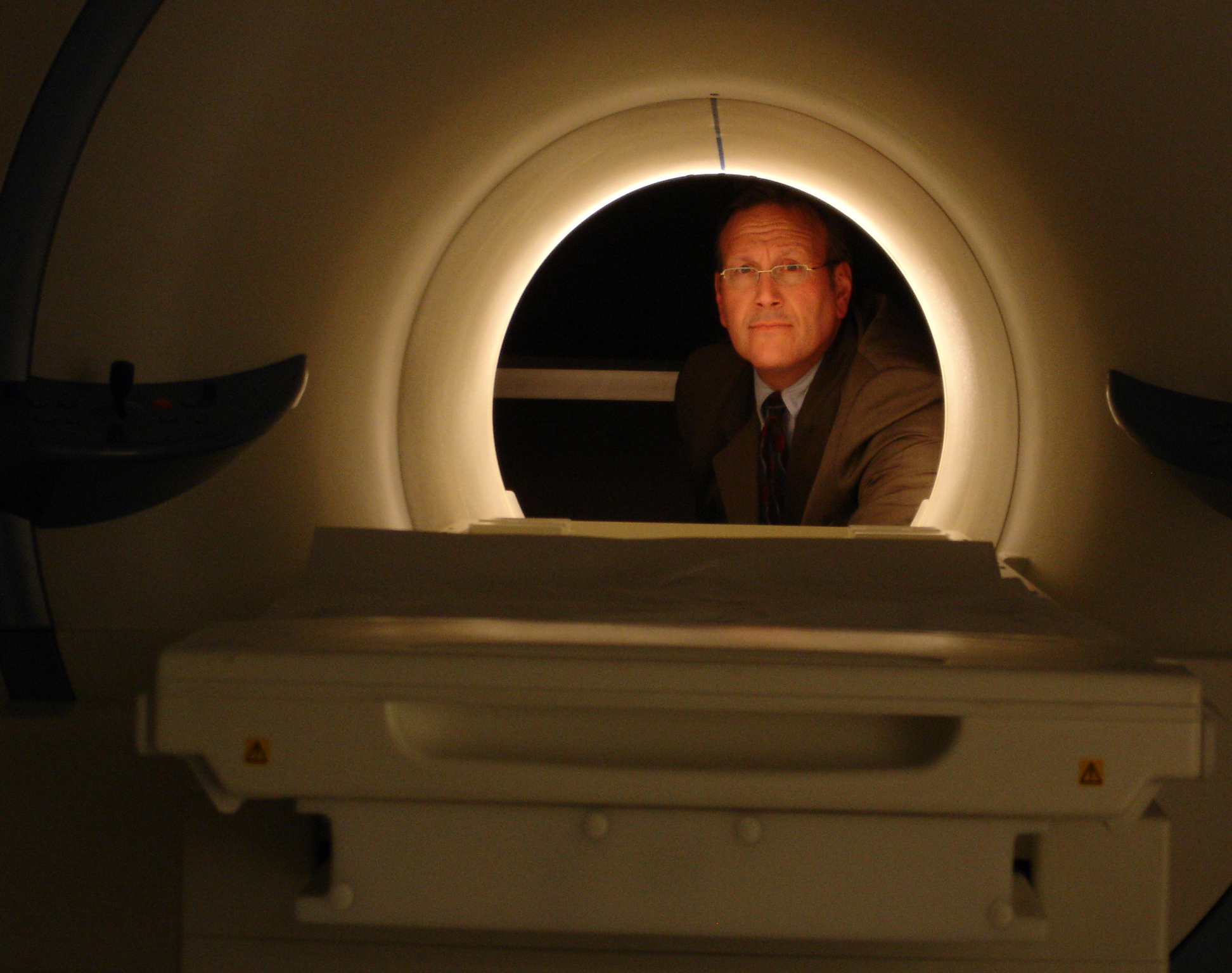 Photo of UC Davis cognitive neuroscientist Ron Mangun looking through brain imaging device. 