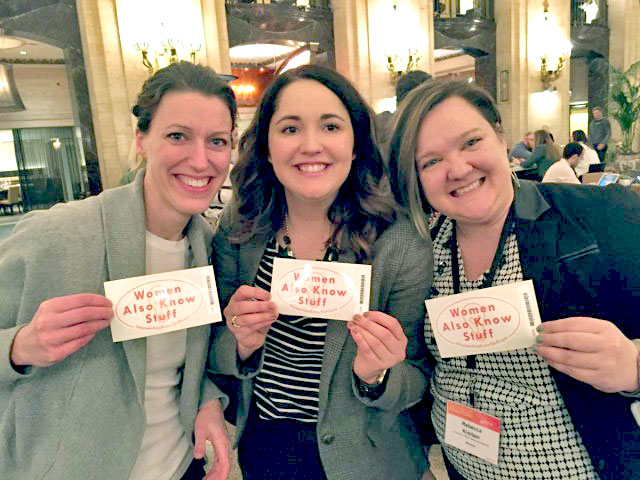 Three women holding stickers