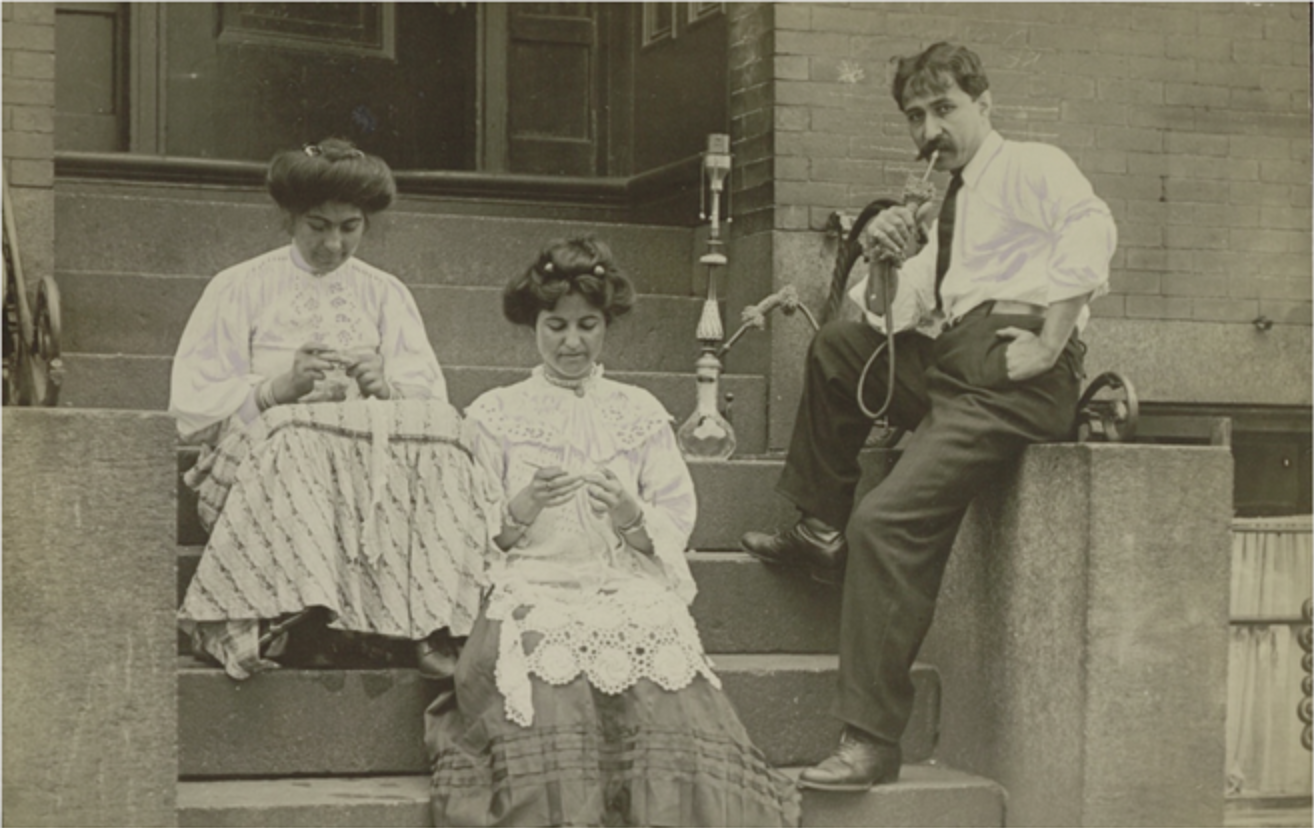 historic photo of two women working lace and a man smoking a hookah