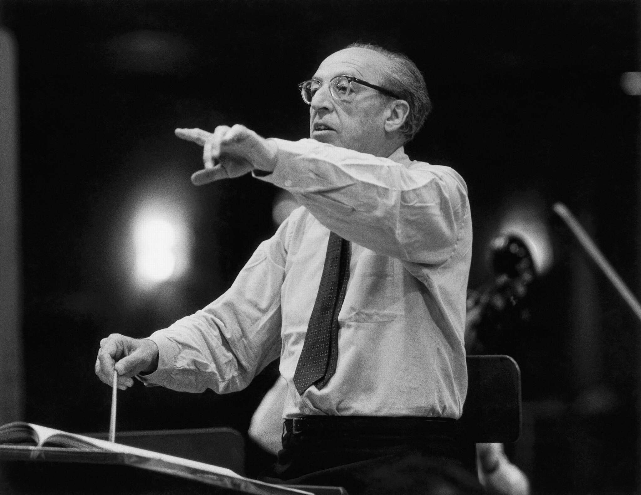 A black and white image of Aaron Copland conducting