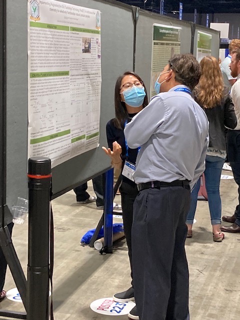 Bao Vue describes her research to an observer during a recent conference. 