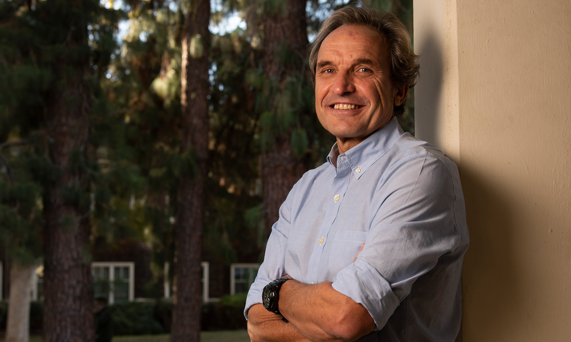 UC Davis psychology professor Emilio Ferrer leans against a building column on campus