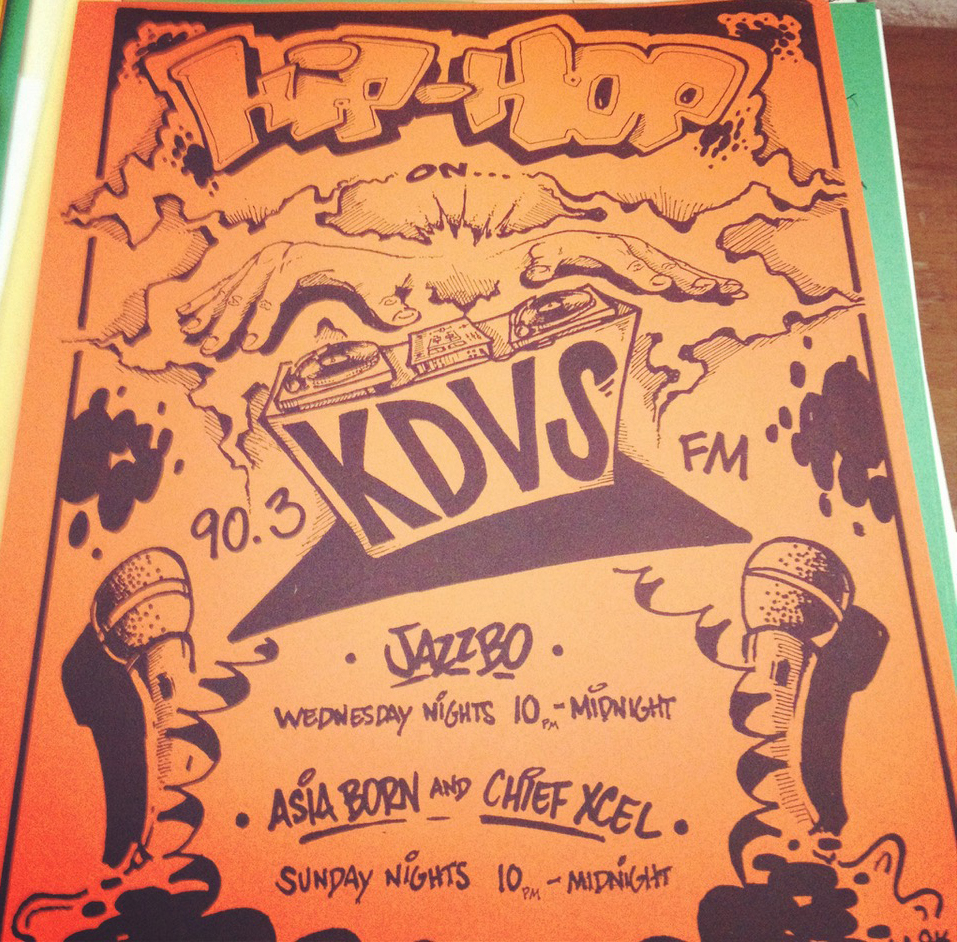 Poster with stylized drawings of microphones and two hands hovering over turntables. Text reads: “Hip-hop on KDVS, 90.3 FM, Jazzbo, Wednesday nights 10 p.m.-midnight. Asia Born and Chief Xcel, Sunday nights 10 p.m.-midnight.”