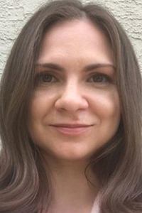 Portrait photo of UC Davis psychology faculty, female, slight smile, wavy long brown hair 