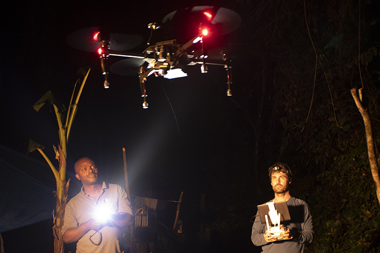 Two researchers operate a drone fitted with an infrared camera during field research in Congo. 