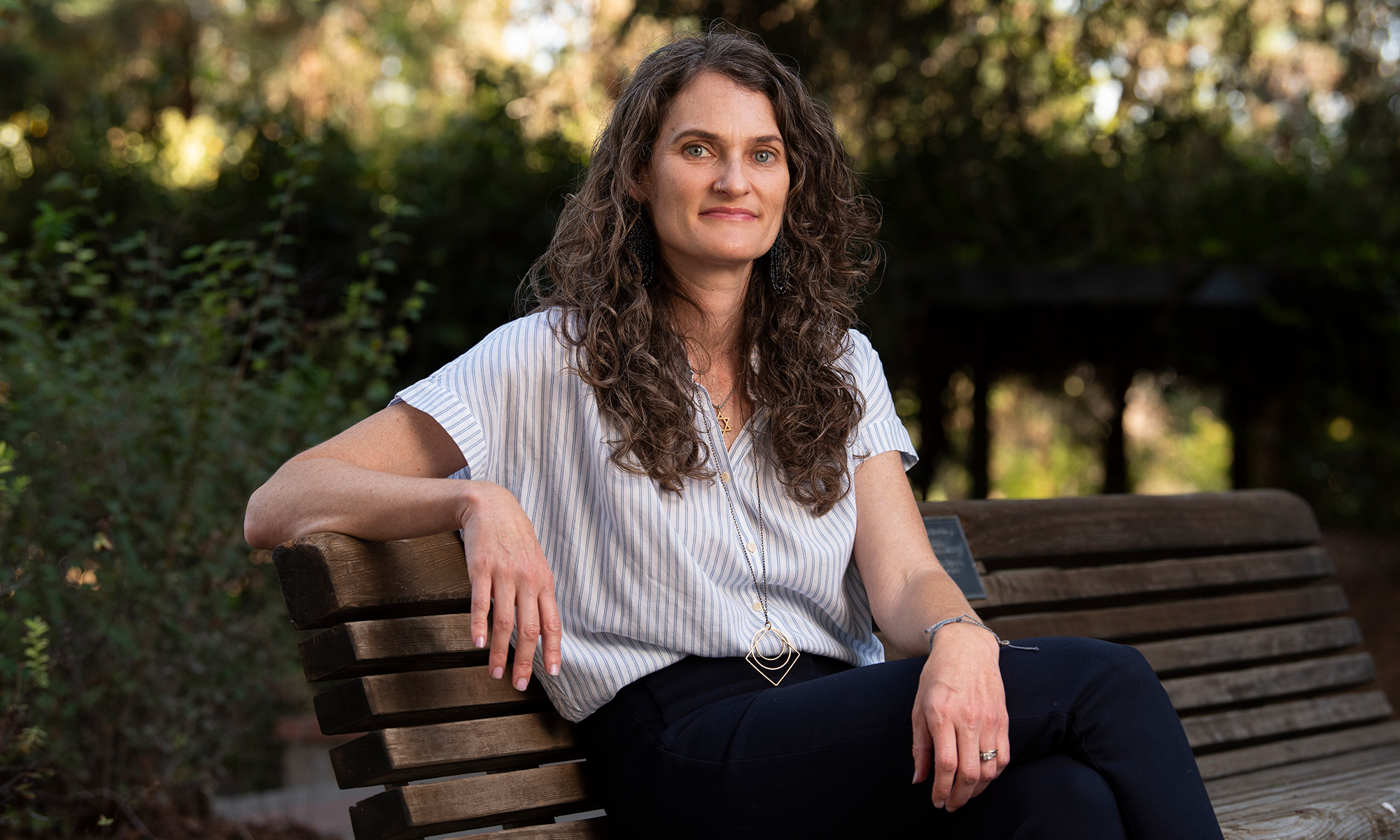 UC Davis human ecology professor Leah Hibel sits on a park bench on campus