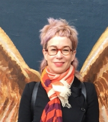 image of women with glasses, pinkish hair, dark jacket, red scarf, from chest up