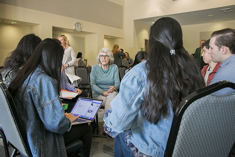 Photo of professor and students talking in a circle