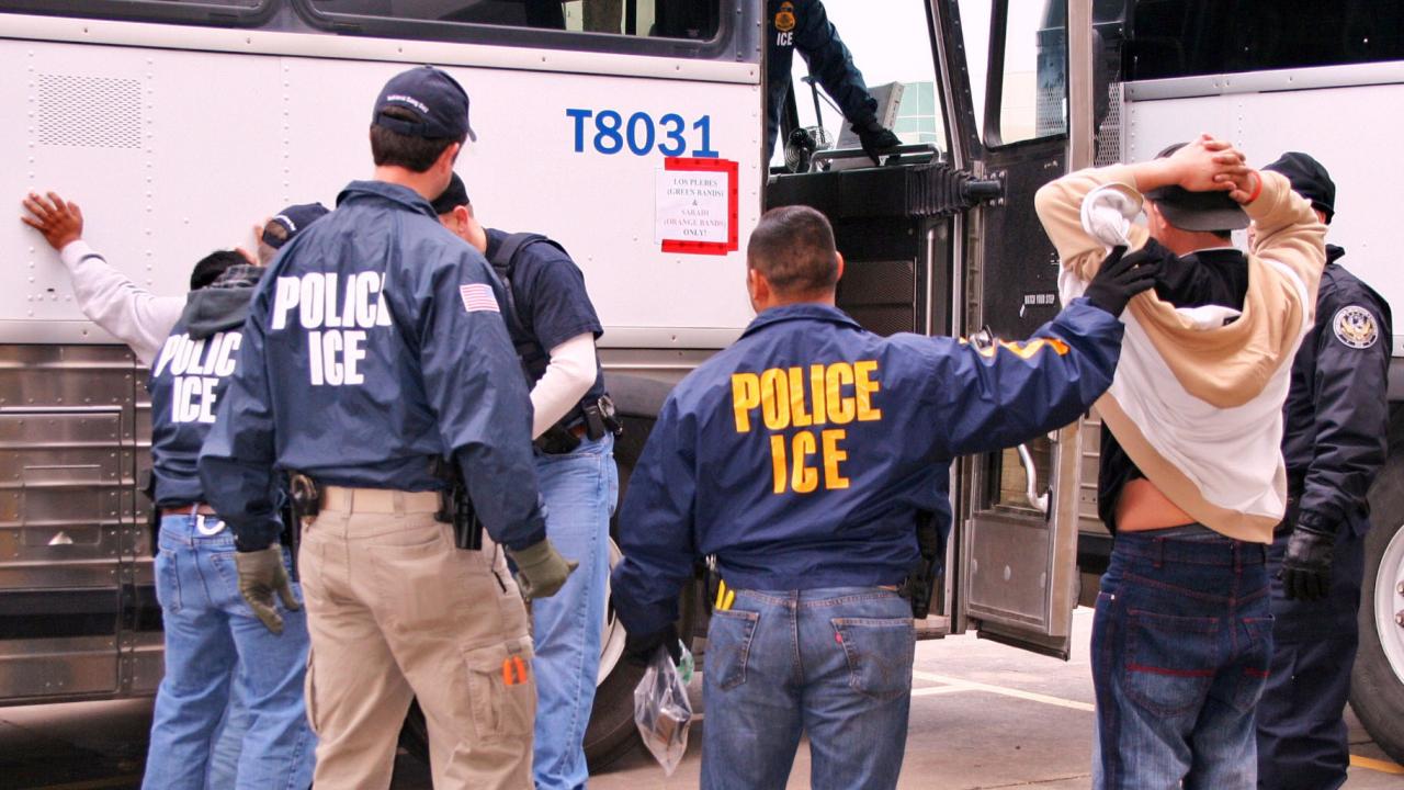 U.S. Immigration and Customs Enforcement officers make arrests during a raid. Proponents of the Secure Communities program, which involves local police cooperation with ICE, argue that it helps fight crime. But a study by UC Davis economists found no link between deportations and crime rates. (ICE photo) Photo of immigration officials making arrests by a bus