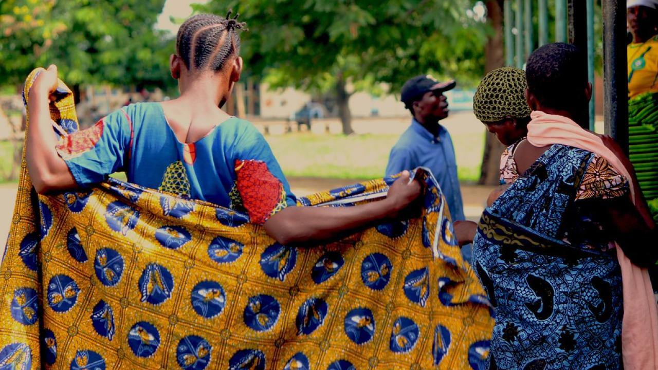 Research by a UC Davis anthropologist in Tanzania finds that women who marry multiple times have more surviving children. This photo shows families at a maternal health clinic. (Creative Commons/White Ribbon Alliance) Women, one holding a colorful wrap, and another carrying a baby on her back, line up at a health clinic in Tanzania.