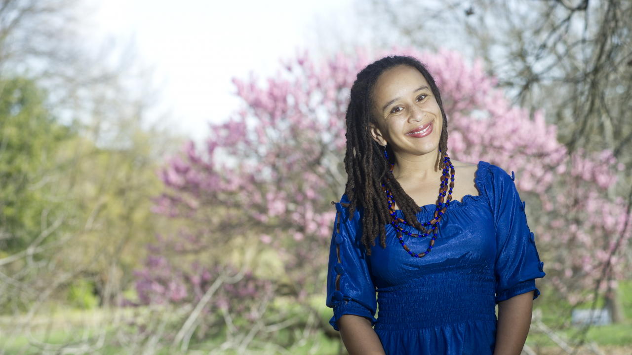 Photo of UC Davis professor standing outside with blossoming tree in background