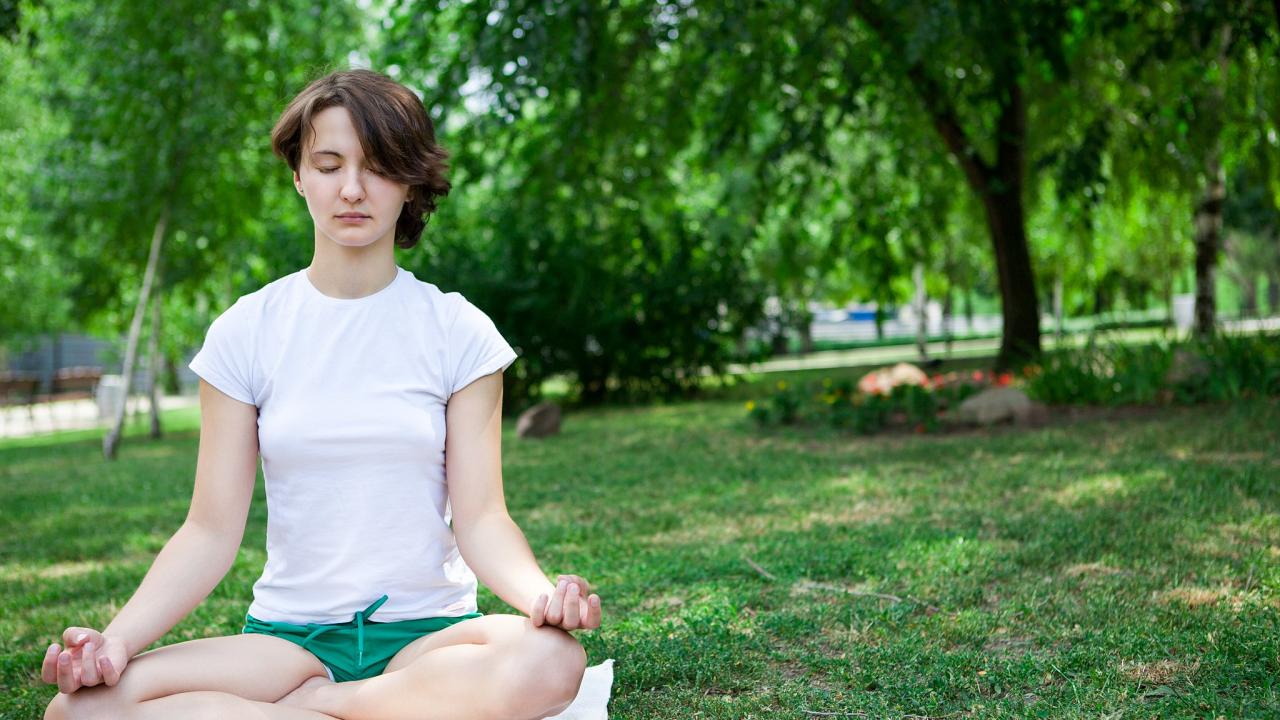 Photo: young woman meditating outdoors
