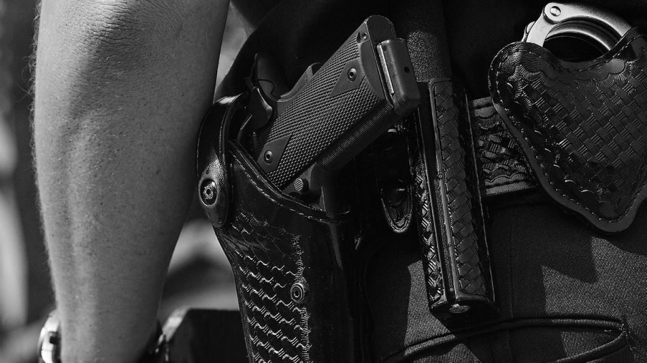 Photo of gun in holster on the hip of a police officer
