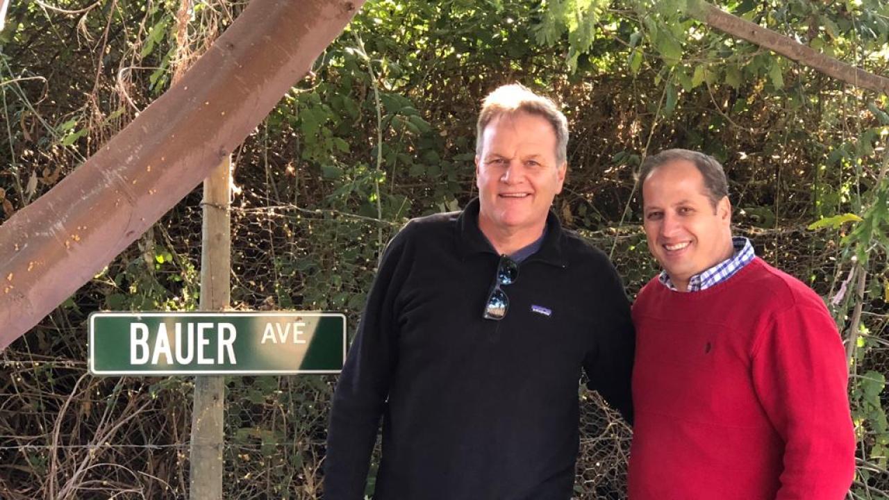 UC Davis history professor Charles Walker and alumnus Fernando Purcell pose near a sign honoring the late UC Davis historian Arnold Bauer at Purcell's family vineyard in Chile. “I don’t know of a single international alum who promotes UC Davis as much as Fernando,” Walker said. (Photo courtesy of Charles Walker) Photo: UC Davis history professor and alum standing next to sign that reads "Bauer Ave"