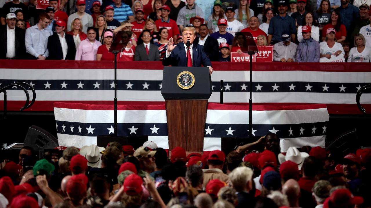 President Donald Trump speaking at podium, surrounded by supporters