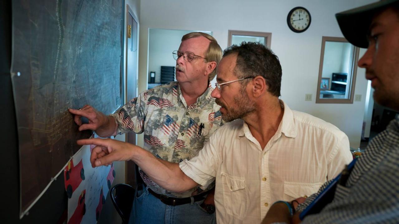 Left to right: Dennis Knobloch, Nicholas Pinter and James “Huck” Rees look at a map of Valmeyer in the village offices.