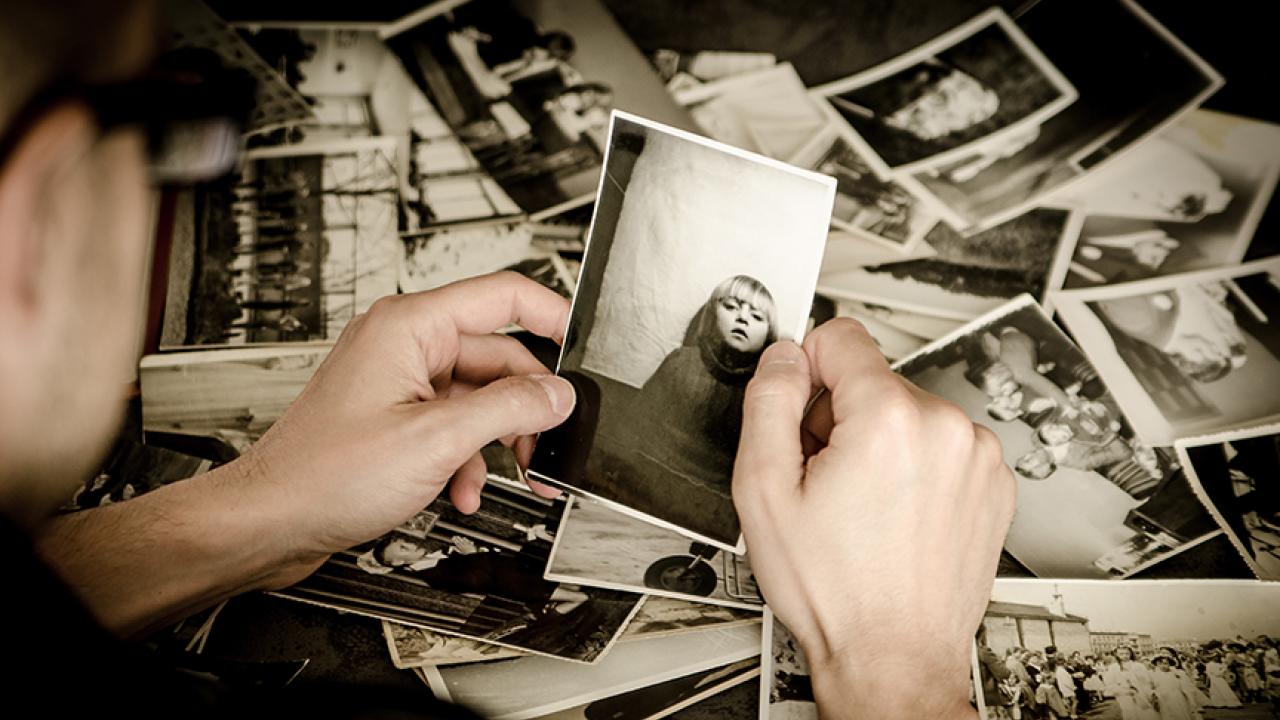 Photo: adult looking at old photo of child