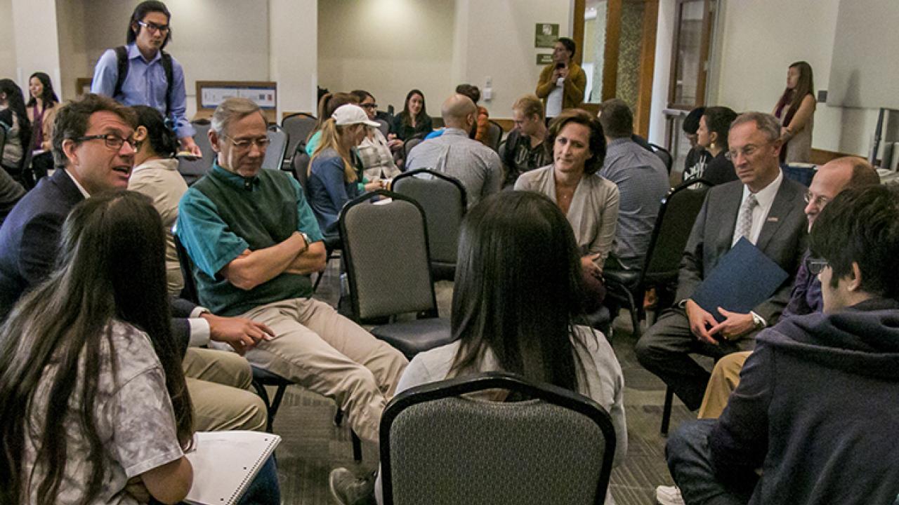 Photo of professor and students talking in a circle