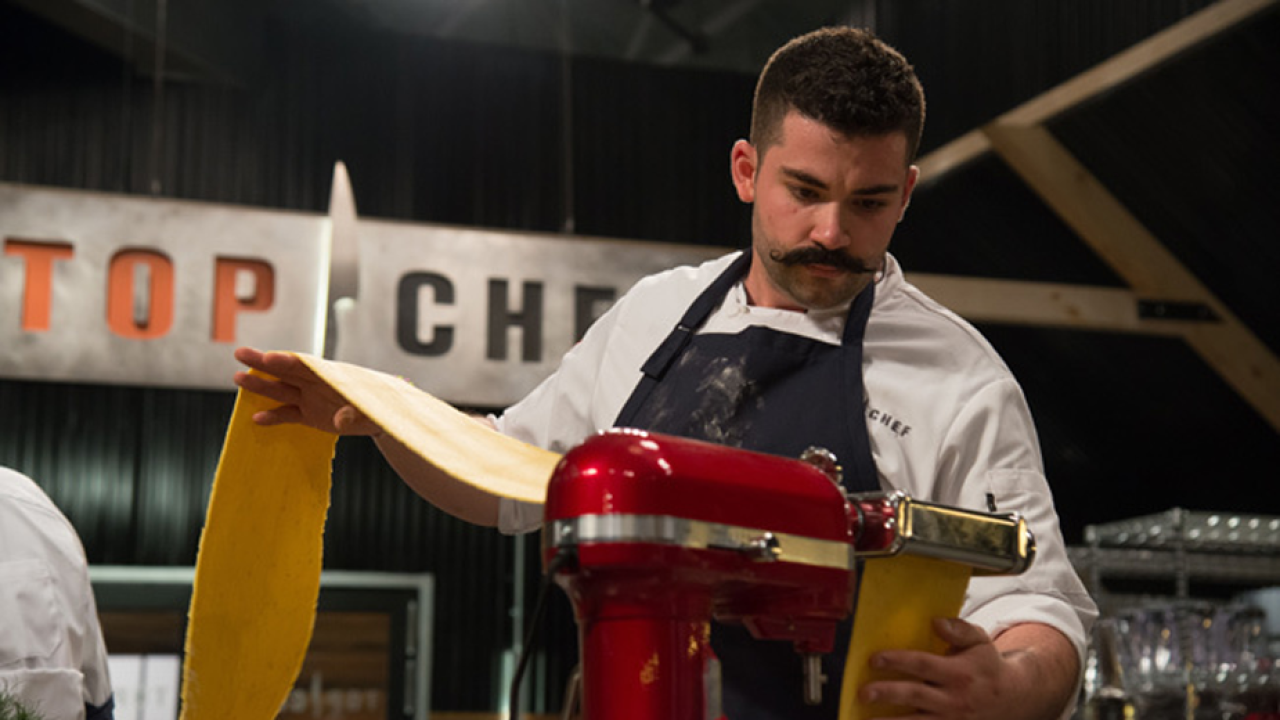 UC Davis alumnus Joe Sasto works his pasta magic on “Top Chef,” where he’s made it to the Final 3. (Bravo Media) Photo: chef holding sheet of pasta dough as it come out of mixer attachment