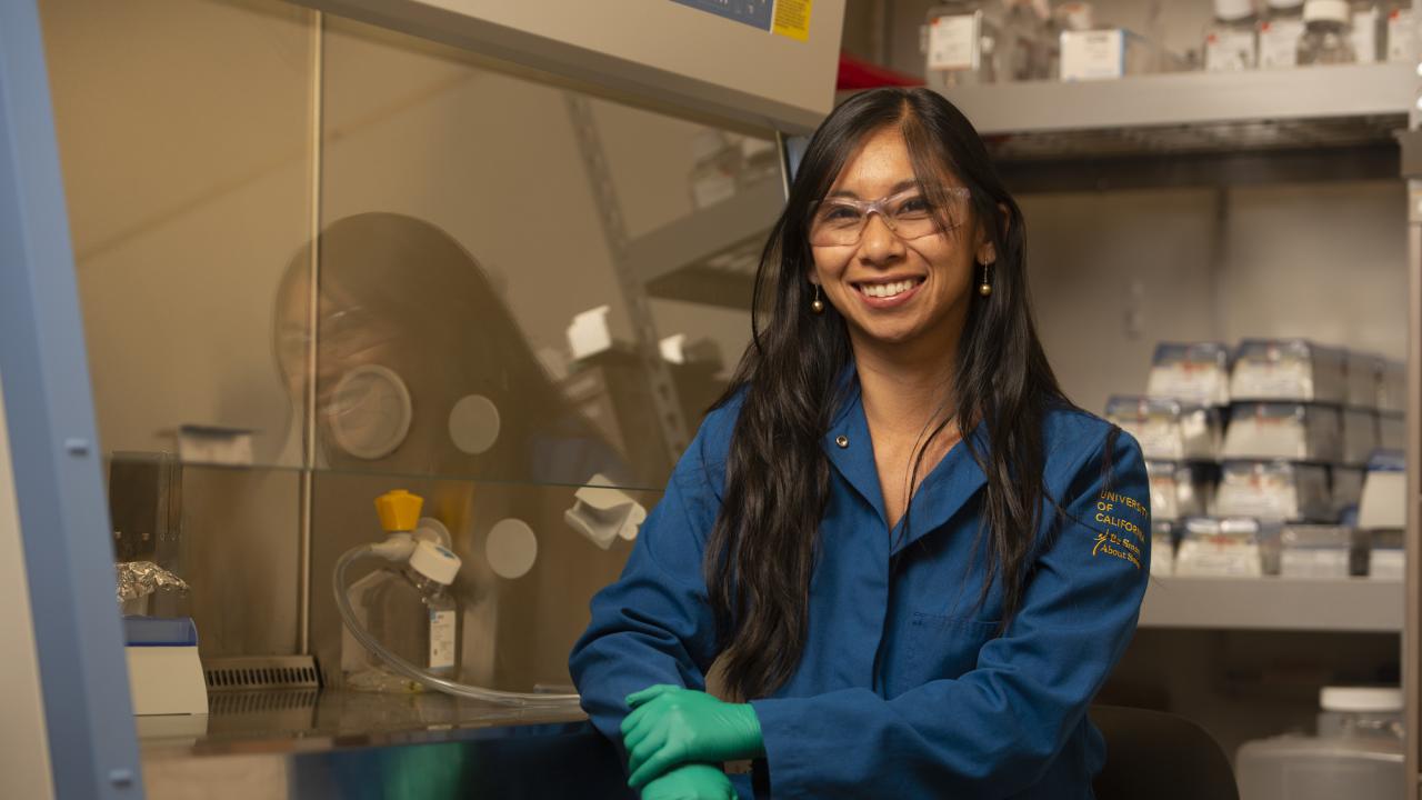 Professor Marie Heffern in a chemistry lab wearing a blue lab coat.