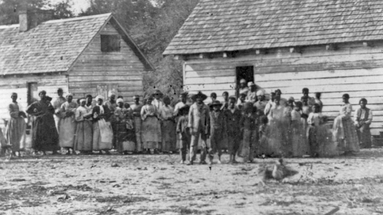 Historic photo of freed slaves standing in front of buildings