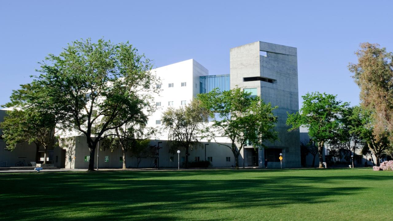 A green lawn leads up to the Social Sciences and Humanities Building.