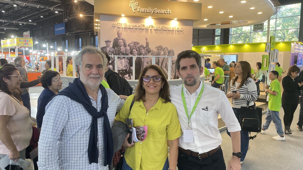Santiago Perez (dressed in a white button-up shirt and black pants) stands with his Mom and Dad at the Buenos Aires Book Fair.