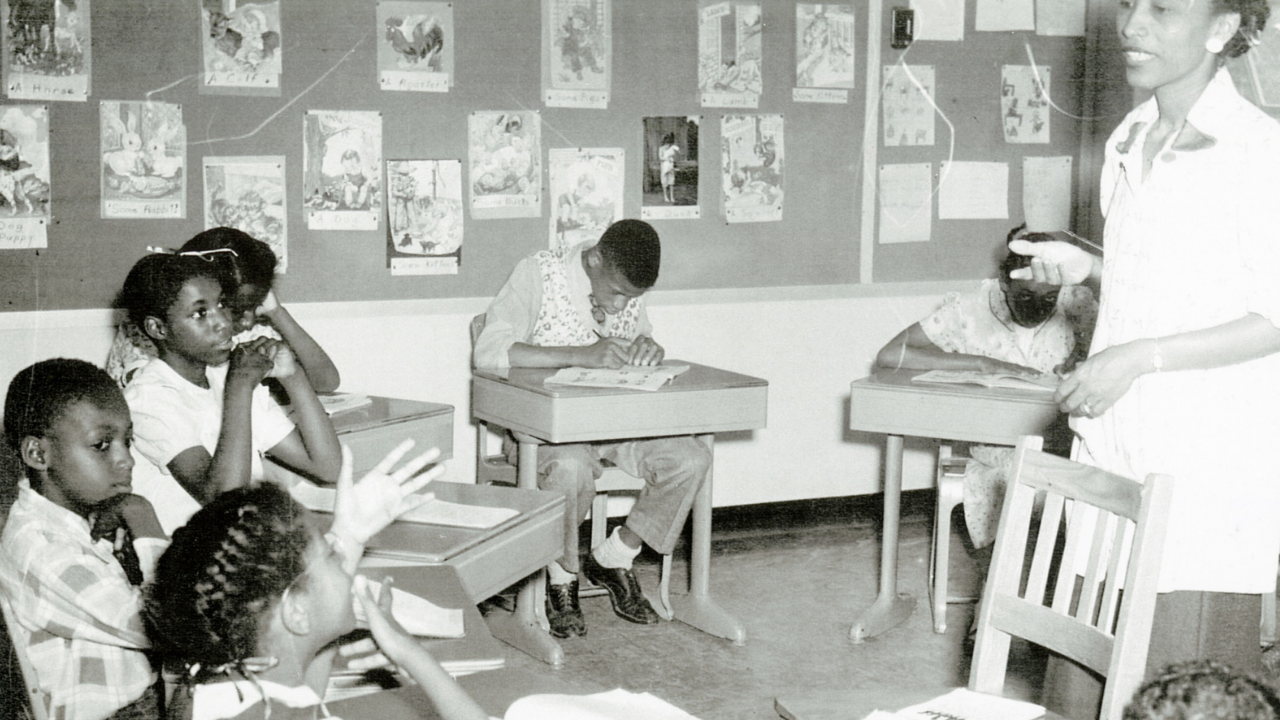 Archival photo of deaf students and teacher in a classroom