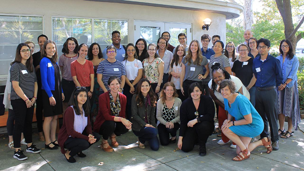 A group portrait of faculty members and graduate fellows from the UC Davis Center for Poverty and Inequality Research, posing in front of International House Davis. 