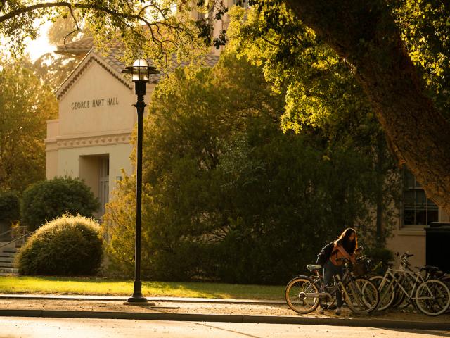 A student parks their bike in golden light at Hart Hall