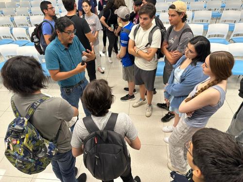 Manuel Calderon de la Barca Sanchez stands in a circle with students as they converse. 
