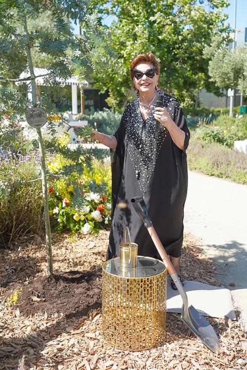 Maria Manetti Shrem at next to Golden Mimosa tree planted in her honor in Margrit Mondavi Art Garden