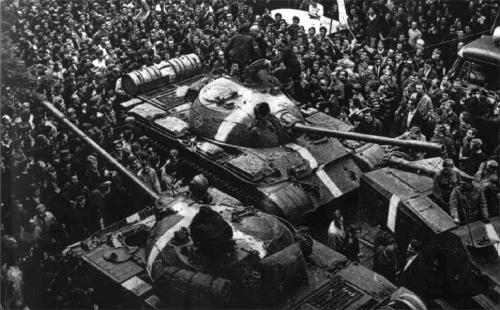A black and white photo of soldiers standing around a large military tank 