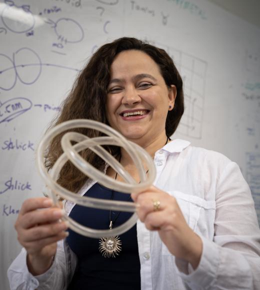 Mariel Vazquez poses with a clear tube looped into a knot. 