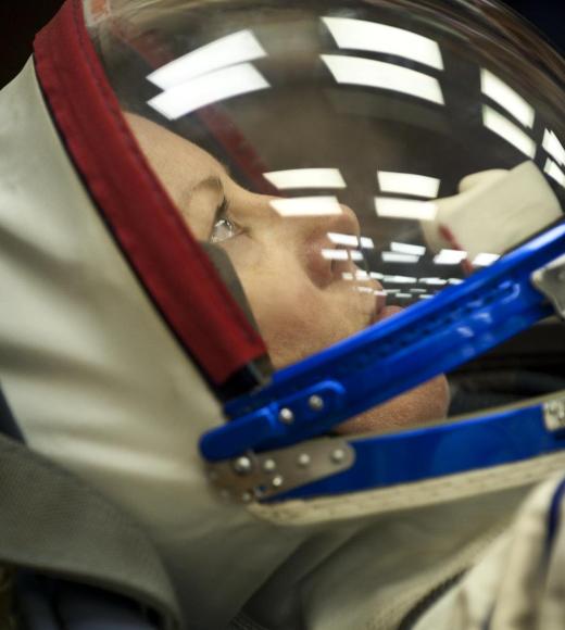 A closeup picture of astronaut Tracy Dyson with her helmet on and looking straight up