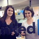 Alumna Emilia Varshavsky Shapiro ’08, right, and colleague Erin Howland display a LinkedIn sign. Emilia was a double major in international relations and English who entered the social media workforce as a technical writer and became a LinkedIn internal communication manager. (LinkedIn Courtesy Photo)