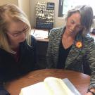 Photo of two UC Davis faculty looking at book on table