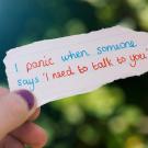 hand holding note that says "I panic when someone says 'I need to talk to you'"