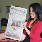 Photo: Nicki Sun looking at Las Vegas newspaper with photo of her on the front page. 