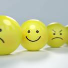 Four emoji-style balls, with one smiling and the others frowning