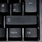computer keyboard with word "blame" on shift key