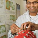 Charan Ranganath smiles while working with a patient wearing a brain cap.