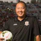 Brent Sasaki holds a soccer ball.