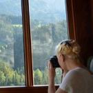 An English major looks out a window with binoculars.
