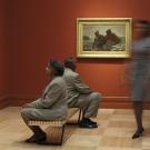 photo of people in art gallery looking at paintings