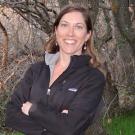 Kristine Gilbert wears a black Patagonia jacket and crosses her arms.
