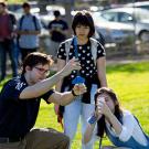 Students stand in a lawn.