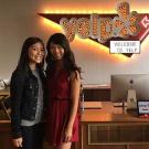 Sarah Ng and Julia Ng pose in front of the front desk at Yelp.