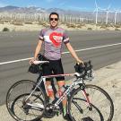 Tim Mizrahi poses in front of a bicycle on the side of a road.